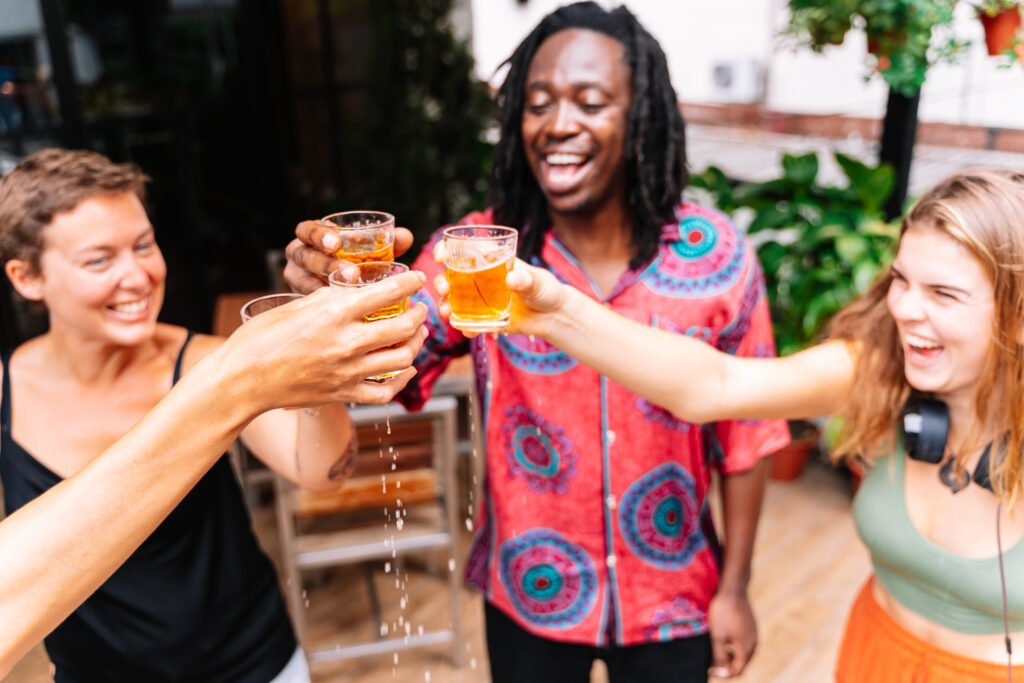 group of four people from different ethnic groups toasting with beer on a terrace group of four people from different ethnic groups toasting with beer on a terrace